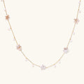 Gold vermeil chain with iridescent star-shaped baroque pearls and small round freshwater pearl drops on cream background.